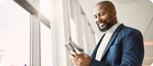 Homem de negócios sorrindo olhando o celular